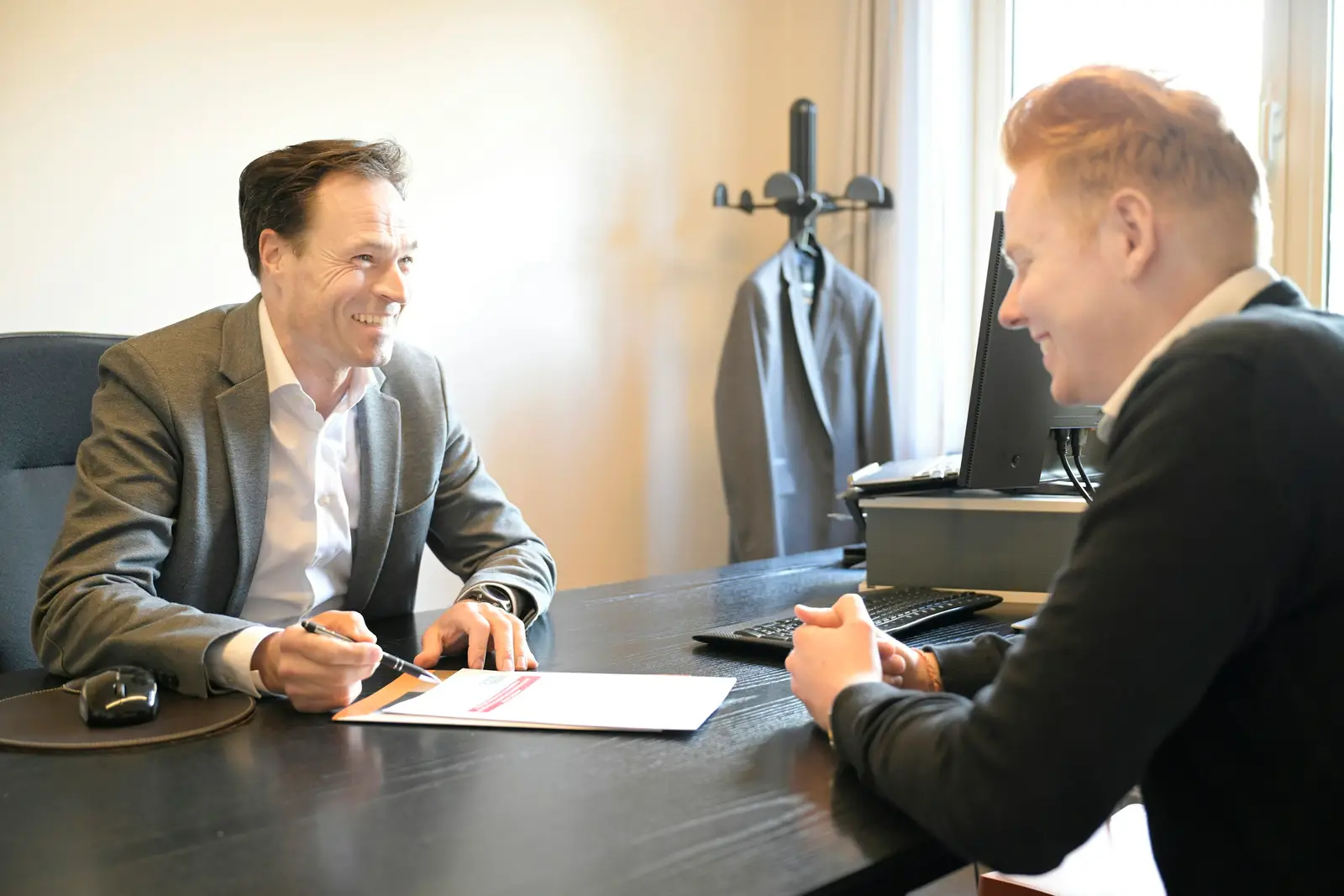 Zwei Männer besprechen Unterlagen an einem Schreibtisch