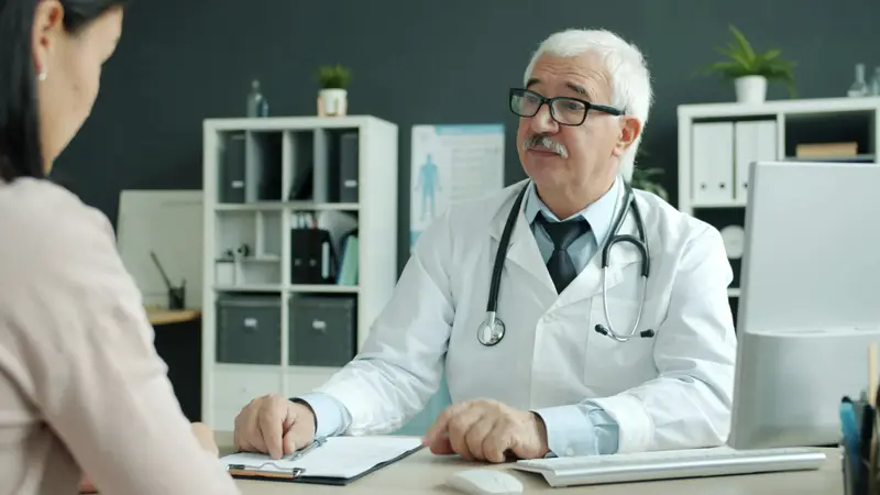 Internist im Gespräch am Schreibtisch