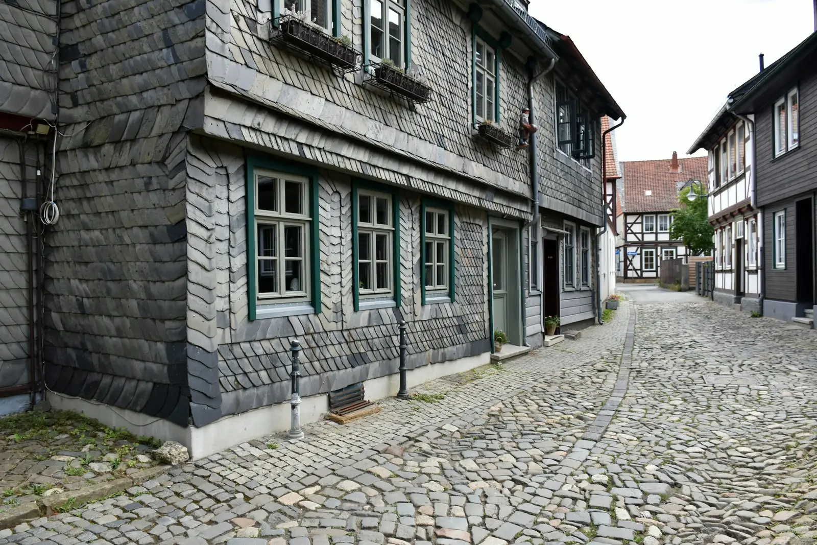 Altbau mit Fassade aus Naturschiefer an einer gepflasterten Gasse
