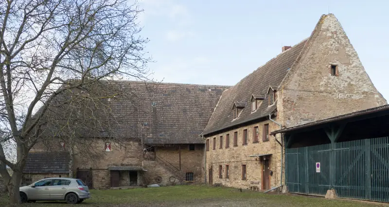 Altes Hofgebäude aus Sandstein mit großem Dach