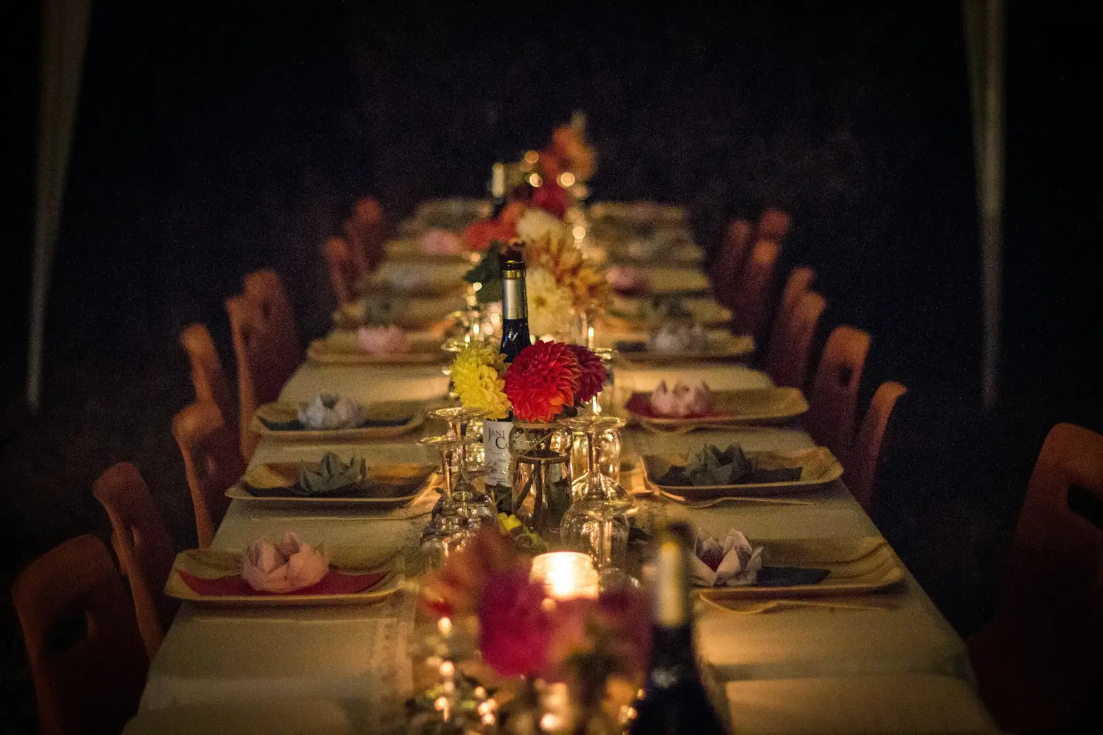 Lange Tafel mit Kerzen und Blumen, gedeckt für eine Feier