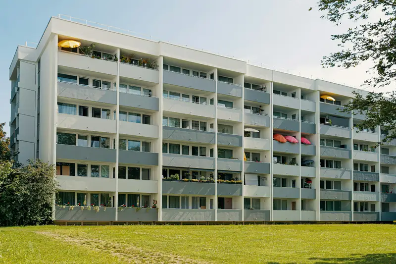 Wohnhaus aus den 60er-Jahren mit Balkonen und Rasen