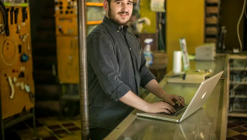 Handwerker am Laptop in seiner Werkstatt