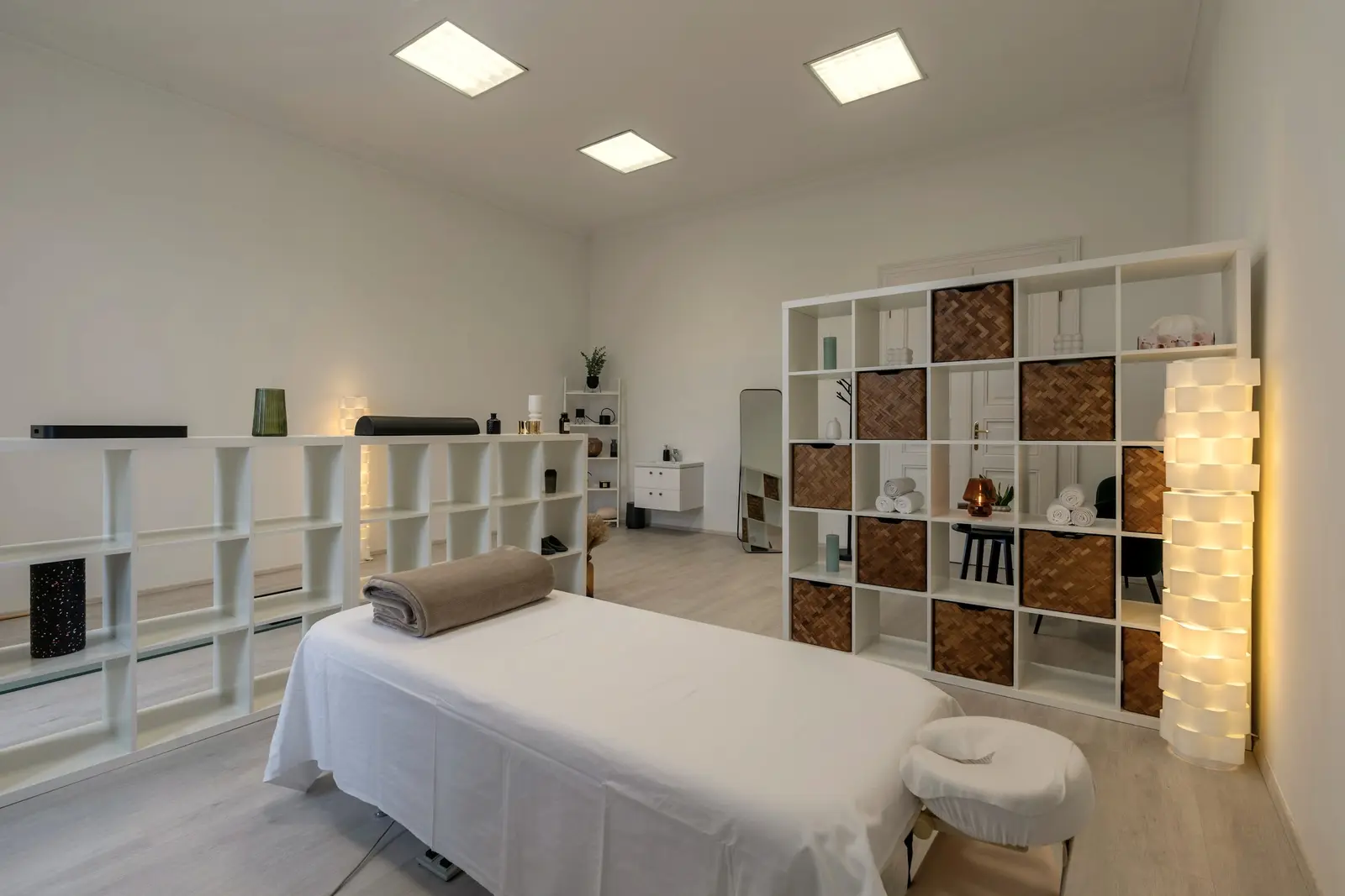 Heller Behandlungsraum mit Liege und Regal