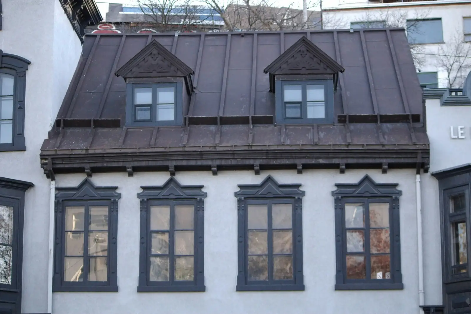 Stadthaus mit Mansarde aus dunklem Stehfalzblech und zwei Gauben