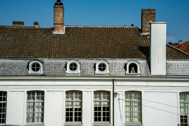 Weißes Stadthaus mit Schieferdach und runden Gauben