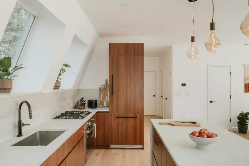 Küche unter der Dachschräge mit Nussbaumschrank und Steinarbeitsplatte